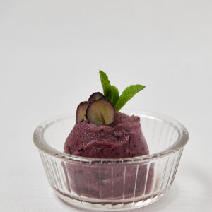 Weintrauben, Minze, Ananas Sorbet in rundem Glassch&auml;lchen mit Blaubeeren und Minze &ndash; Draufsicht