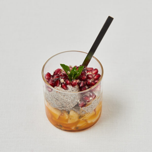 Chia Pudding mit Mango und Granatapfel im Glas – seitliche Studioaufnahme Overhead