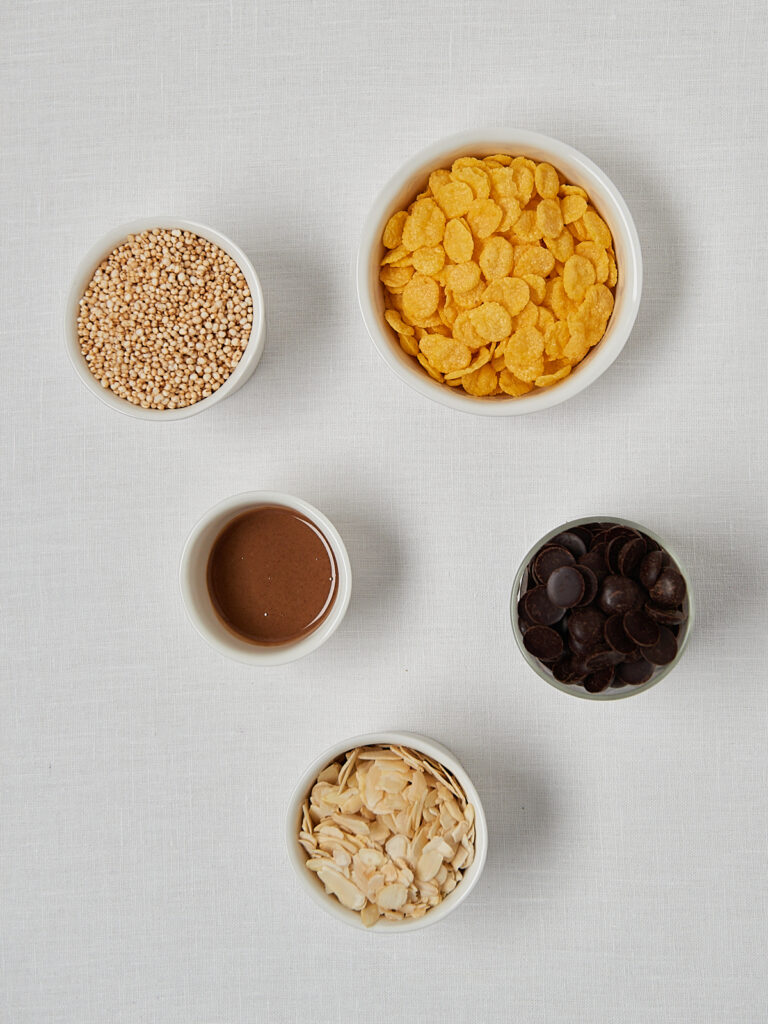 Zutaten-Flatlay Schokocrossies &ndash; Cornflakes, Quinoa, Mandelmus und Dattelschokolade