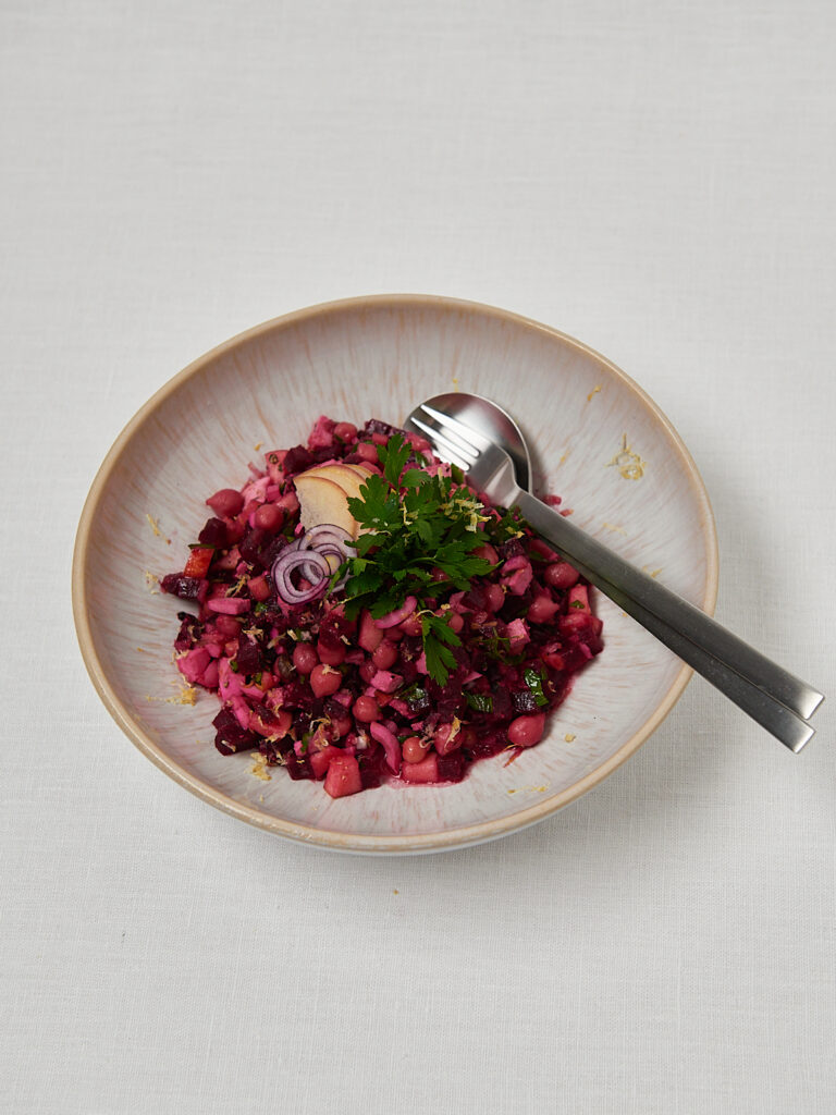 Rote Beete Salat mit Kichererbsen und Petersilie in rosa Sch&uuml;ssel mit Gabel &ndash; gesundes Salatrezept