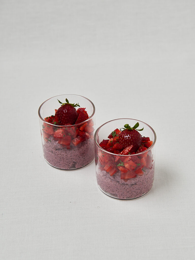 Erdbeer Chia Overnight Oats in Gl&auml;sern mit frischen Erdbeeren &ndash; seitliche Studioaufnahme