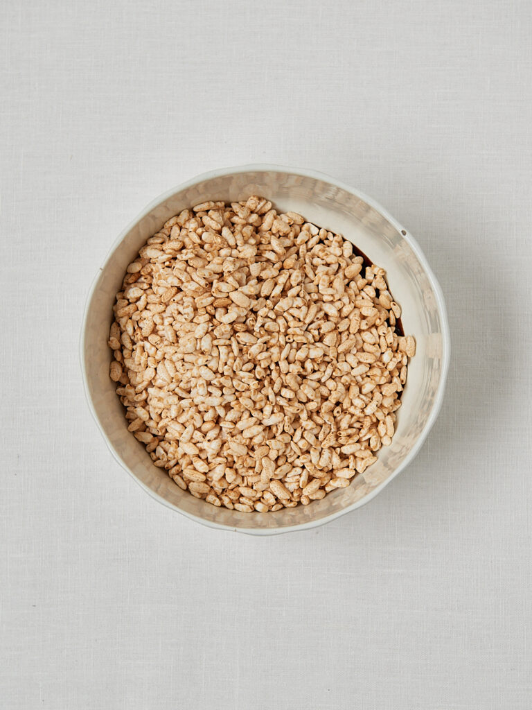 Gepuffter Reis ungekocht in beiger Sch&uuml;ssel &ndash; Zutat f&uuml;r homemade Rice Puff Cereal