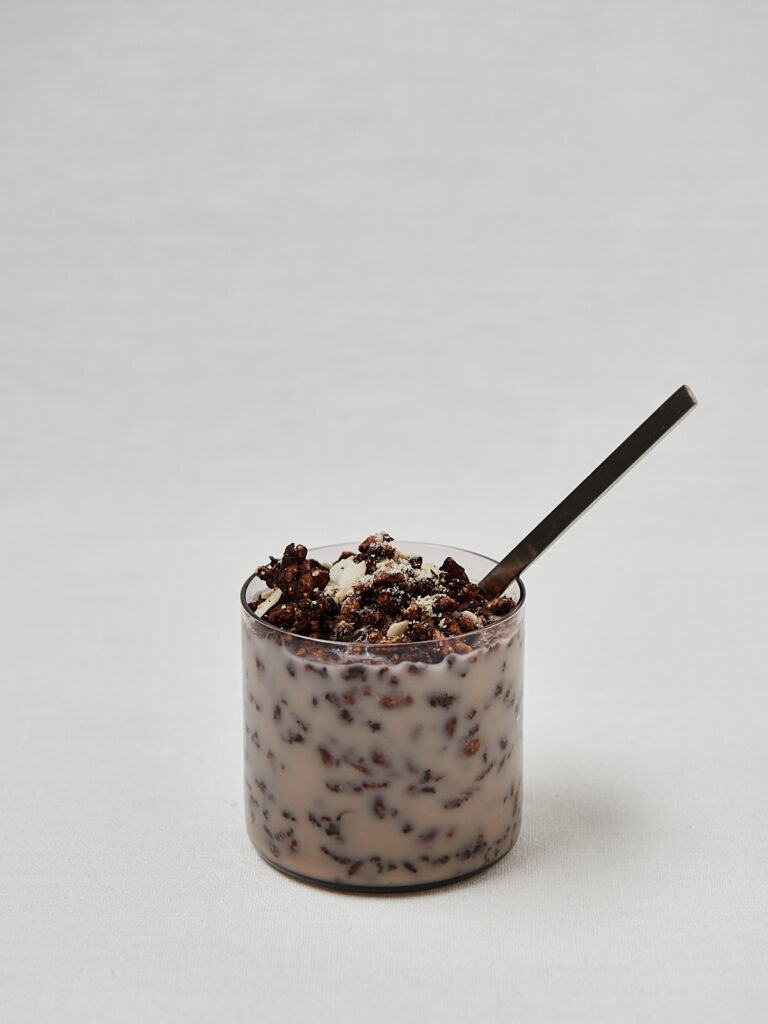 Selbstgemachtes Schoko Rice Puff Cereal in Glasbecher mit schwarzem L&ouml;ffel &ndash; Studioaufnahme