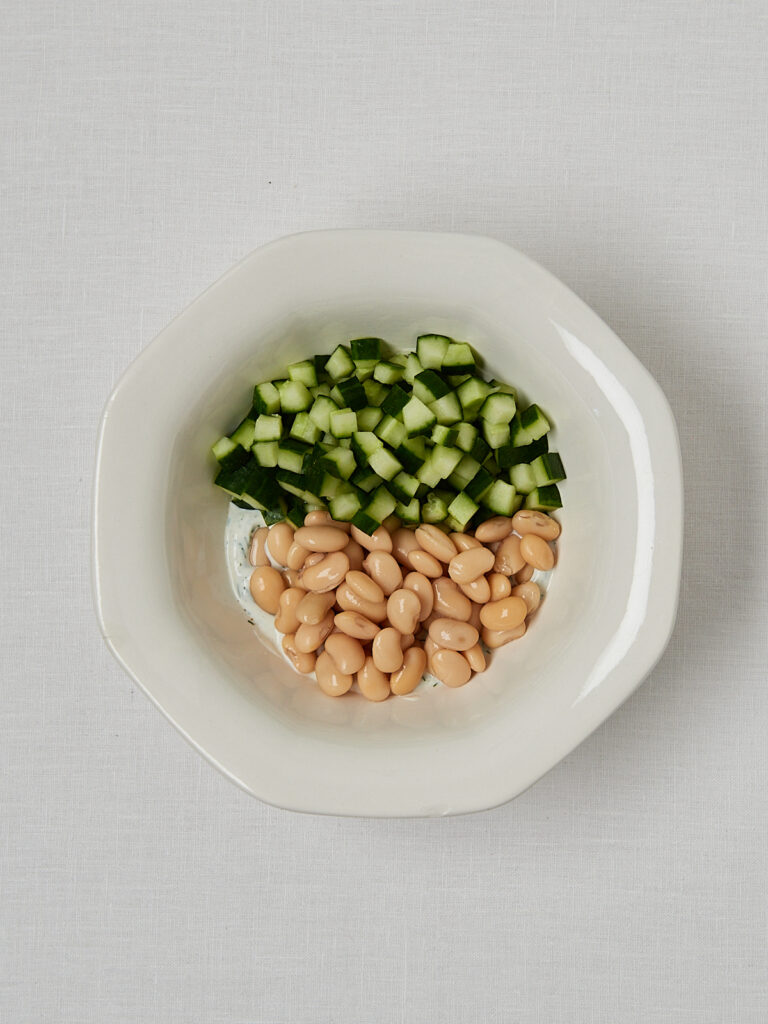 Gewürfelte Gurke und weiße Bohnen in Schüssel – Zubereitungsschritt Gurken Joghurt Bowl