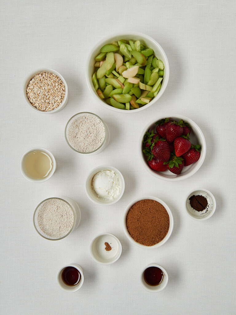 Zutaten-Flatlay Rhabarber Crumble Bars &ndash; Rhabarber, Erdbeeren, Haferflocken, St&auml;rke und Gew&uuml;rze