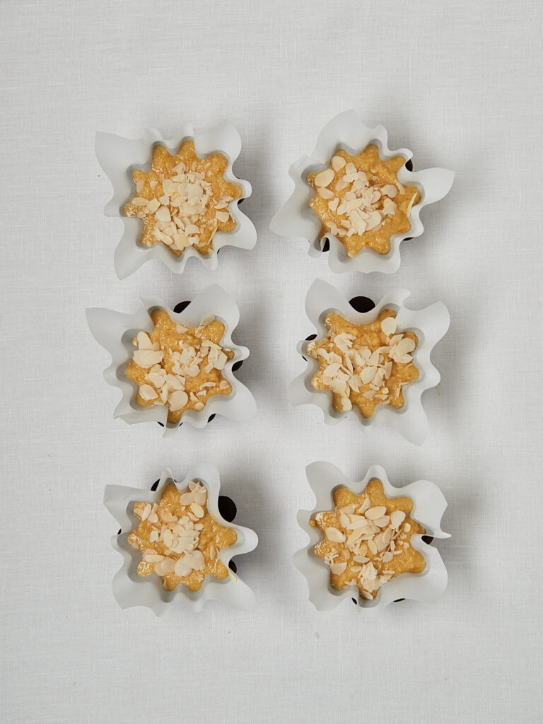 Glutenfreie Orangen Muffins in sternf&ouml;rmigen Metallf&ouml;rmchen &ndash; Draufsicht Backblech