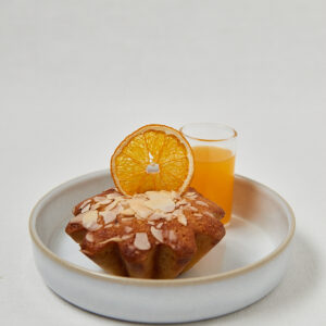 Orange Almond Muffin mit Mandelbl&auml;ttchen und frischem Orangensaft auf Teller