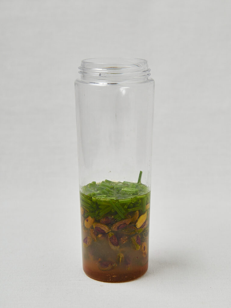 Zitronen Pistazien Dressing in Glasflasche &ndash; Zubereitungsschritt seitliche Aufnahme