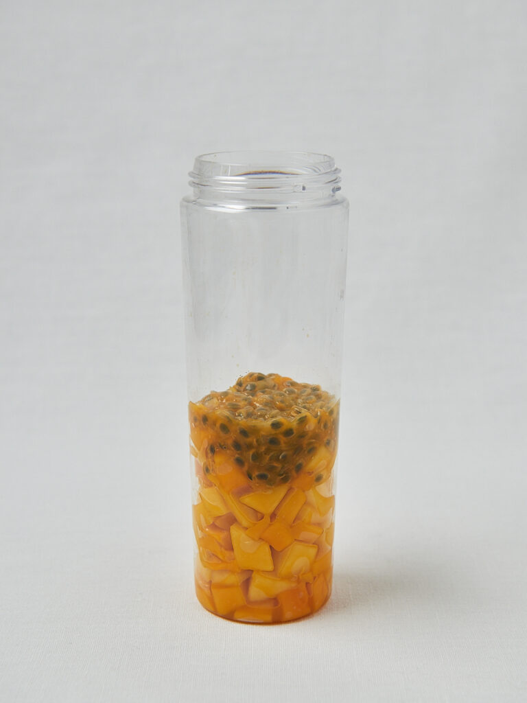 Leere Glasflasche auf hellem Untergrund – Zubereitungsschritt Tropical Skyr Pudding