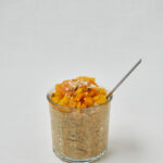 Tropical Chia Skyr Pudding mit Mango-Topping und Löffel – seitliche Studioaufnahme