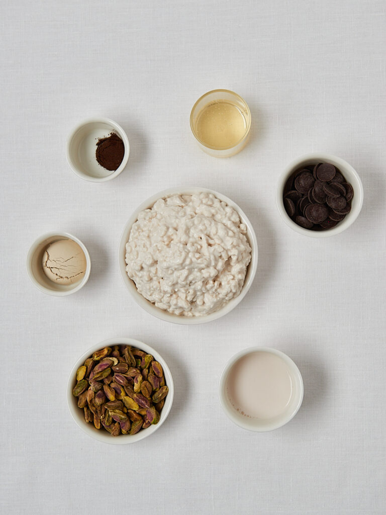 Zutaten-Flatlay High Protein Pistachio Ice Cream – Hüttenkäse, Pistazien, Honig und Proteinpulver