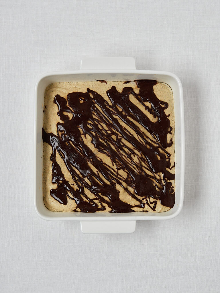 High Protein Pistachio Ice Cream in flacher Form mit Schokoladensoße – Overhead Shot