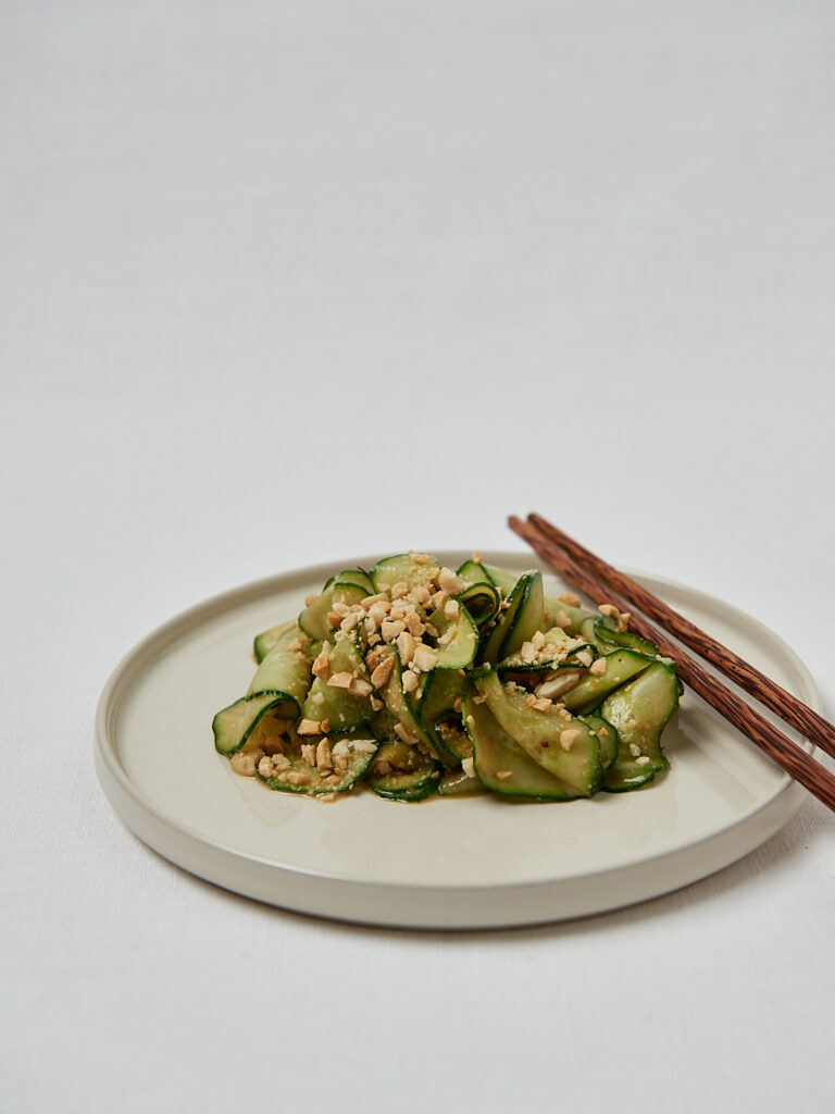 Gurken Erdnuss Salat in weißer Schüssel mit Holzbesteck – Draufsicht Overhead Shot