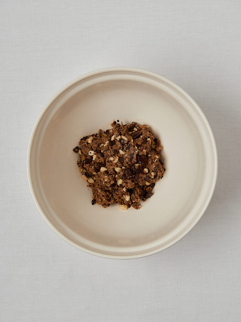 Macadamia Schokolade Hafermehl Teig in beiger Schüssel – Zubereitungsschritt Overhead