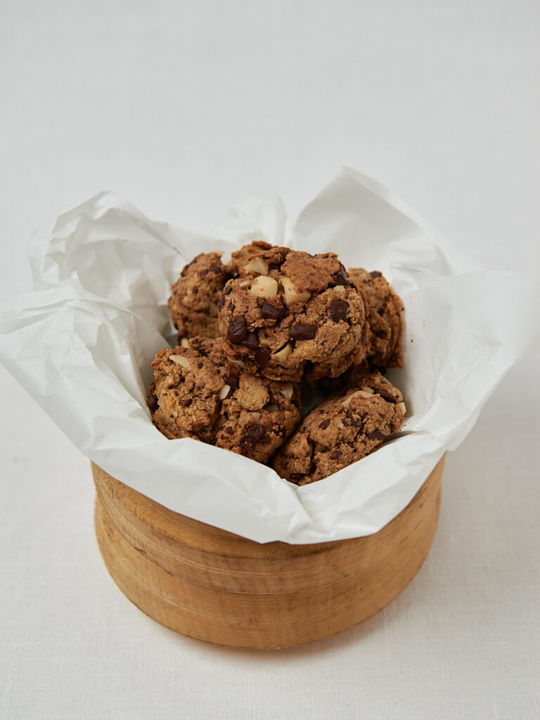 Protein Macadamia Cookie mit Schokoladenstücken in Backpapier – seitliche Aufnahme
