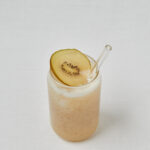 Kiwi Kokoswasser Drink mit Kiwischeibe als Topping – seitliche Aufnahme
