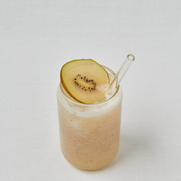 Kiwi Kokoswasser Drink mit Kiwischeibe als Topping – seitliche Aufnahme