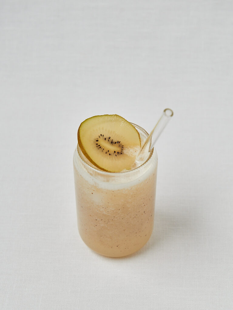 Kiwi Kokoswasser Drink mit Kiwischeibe als Topping – seitliche Aufnahme