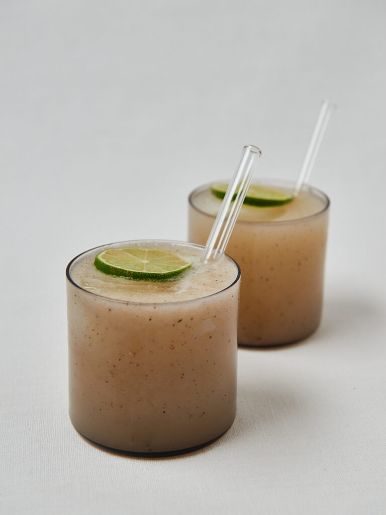 Kiwi Kokoswasser Drink mit Limettenscheibe und Strohhalm – seitliche Studioaufnahme