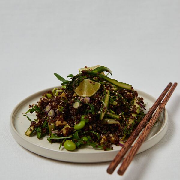Crispy Roasted Quinoa Spargel Salat mit Edamame und Sesam in wei&szlig;er Sch&uuml;ssel mit St&auml;bchen &ndash; gesunder veganer Salat