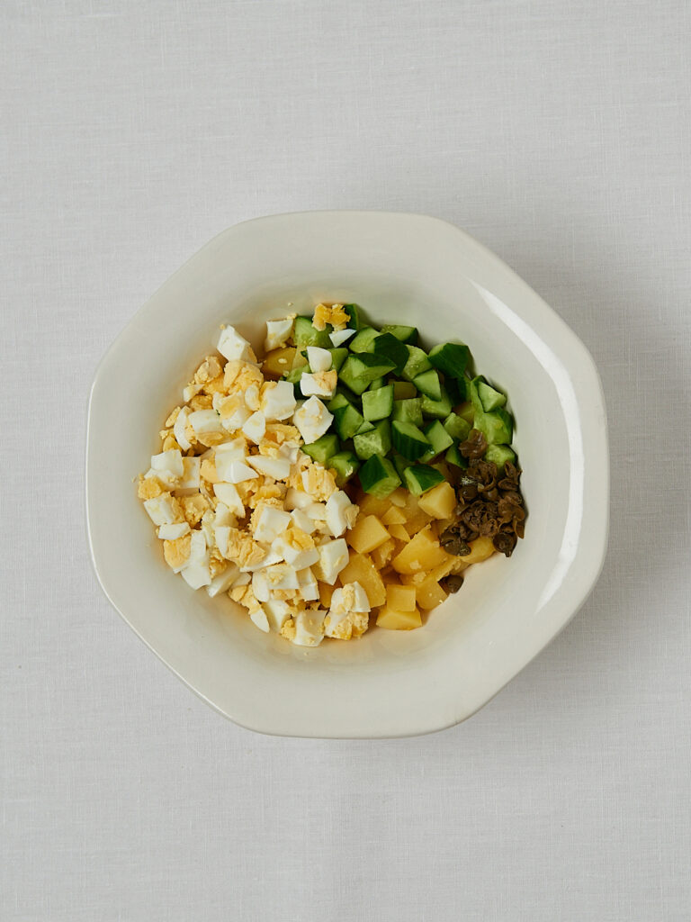 Kartoffeln mit Gurke und Frühlingszwiebeln in Schüssel – Zubereitungsschritt japanischer Salat