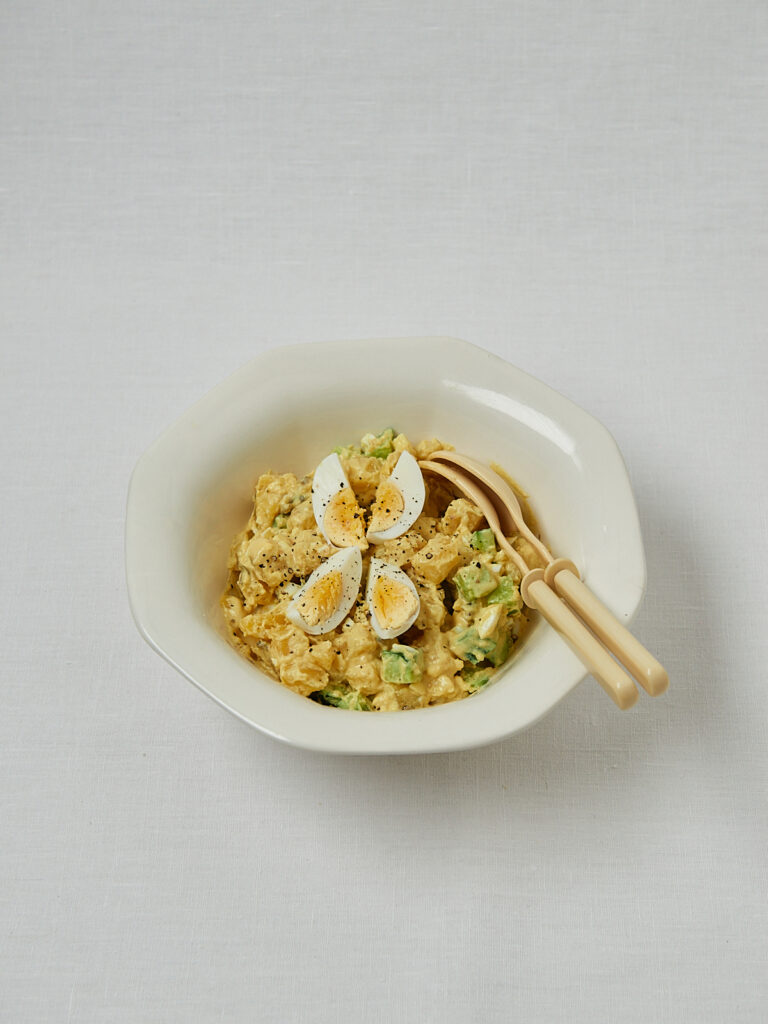 Japanischer Kartoffelsalat mit Holzbesteck und Ei-Topping – Overhead Shot