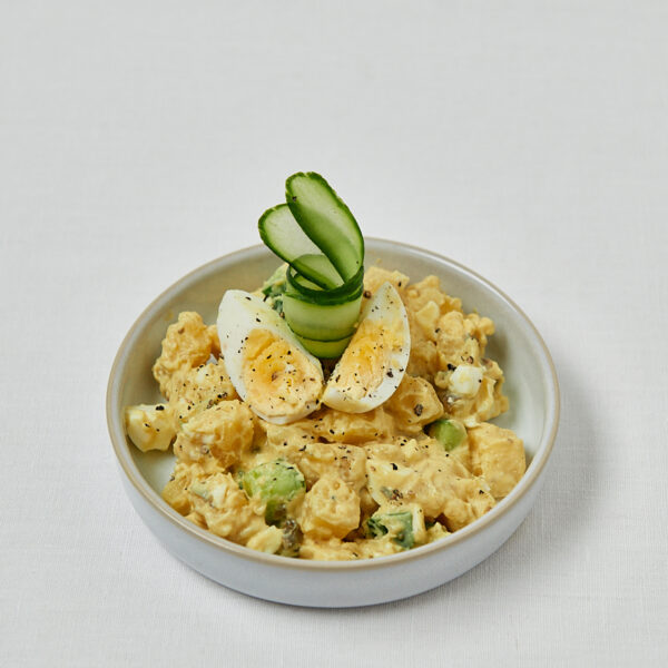 Japanischer Kartoffelsalat mit halbiertem Ei und Gurkenscheiben in weißer Schüssel – gesundes Mittagessen