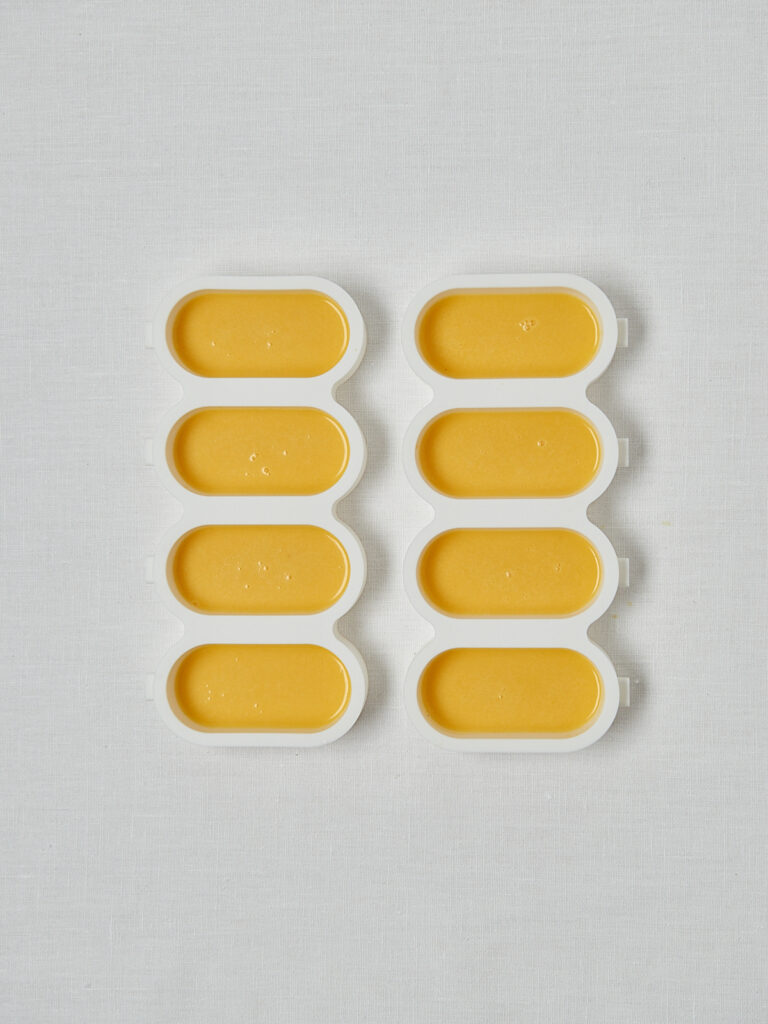 Mandarine Joghurt Pops in Silikonformen – Overhead Shot vor dem Einfrieren