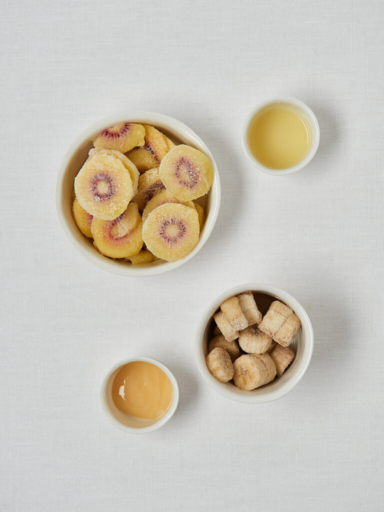 Zutaten-Flatlay Kiwi Nice Cream – gefrorene Kiwischeiben und Honig auf weißem Hintergrund