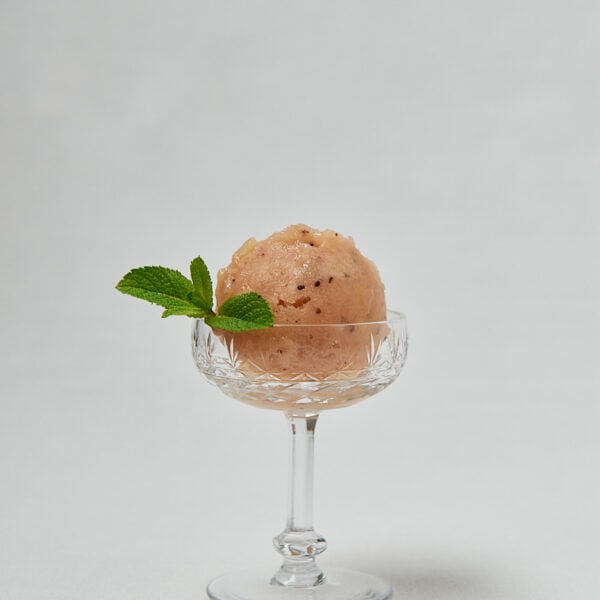 Kiwi Nice Cream Kugel mit frischer Minze auf weißem Teller – veganes Eis ohne Zucker