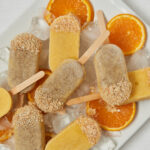 Cremige Mandarine Popsicles mit Orangenscheiben und Kokosstreusel – Draufsicht