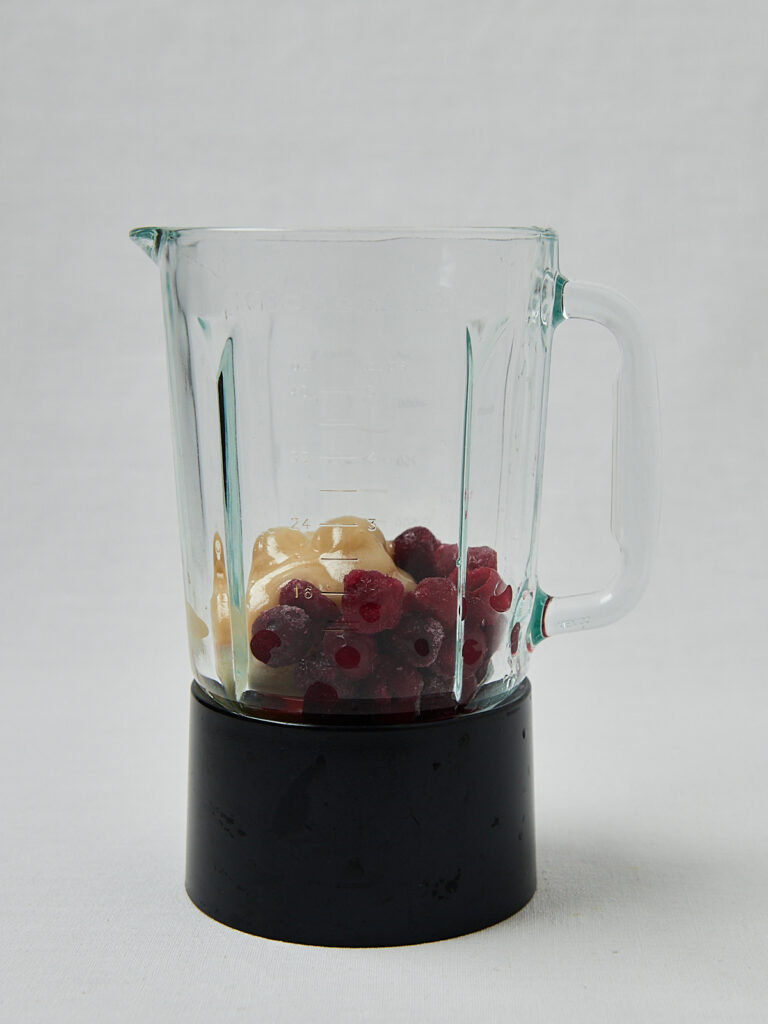 Hibiskus Lemonade im Mixbeh&auml;lter &ndash; rote Fruchtmasse seitliche Aufnahme