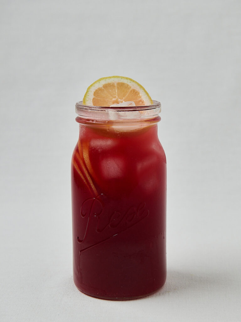 Rote Cherry Hibiskus Lemonade in Glasflasche mit Zitronenscheibe &ndash; Draufsicht
