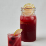 Rote Hibiskus Limonade mit Kirsche und Zitrone im Glas – Overhead Shot