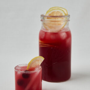 Rote Hibiskus Limonade mit Kirsche und Zitrone im Glas &ndash; Overhead Shot