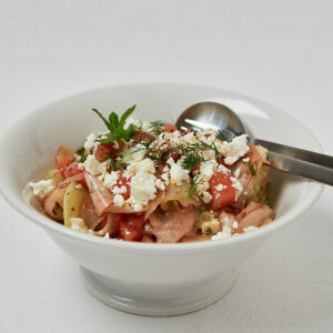 Gurken Pfirsich Salat mit Feta und Minze &ndash; frontale Aufnahme mit Besteck
