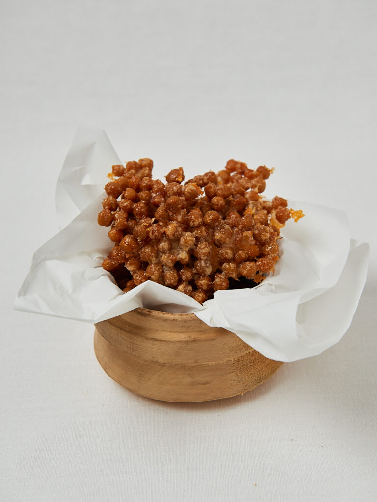 Cheezy Chickpeas auf Backpapier in Schüssel – frontale Aufnahme