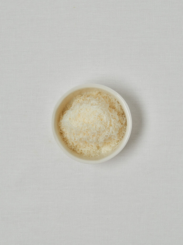 Geriebener Parmesan in wei&szlig;er Sch&uuml;ssel &ndash; Zutat f&uuml;r knusprige Parmesan Croutons
