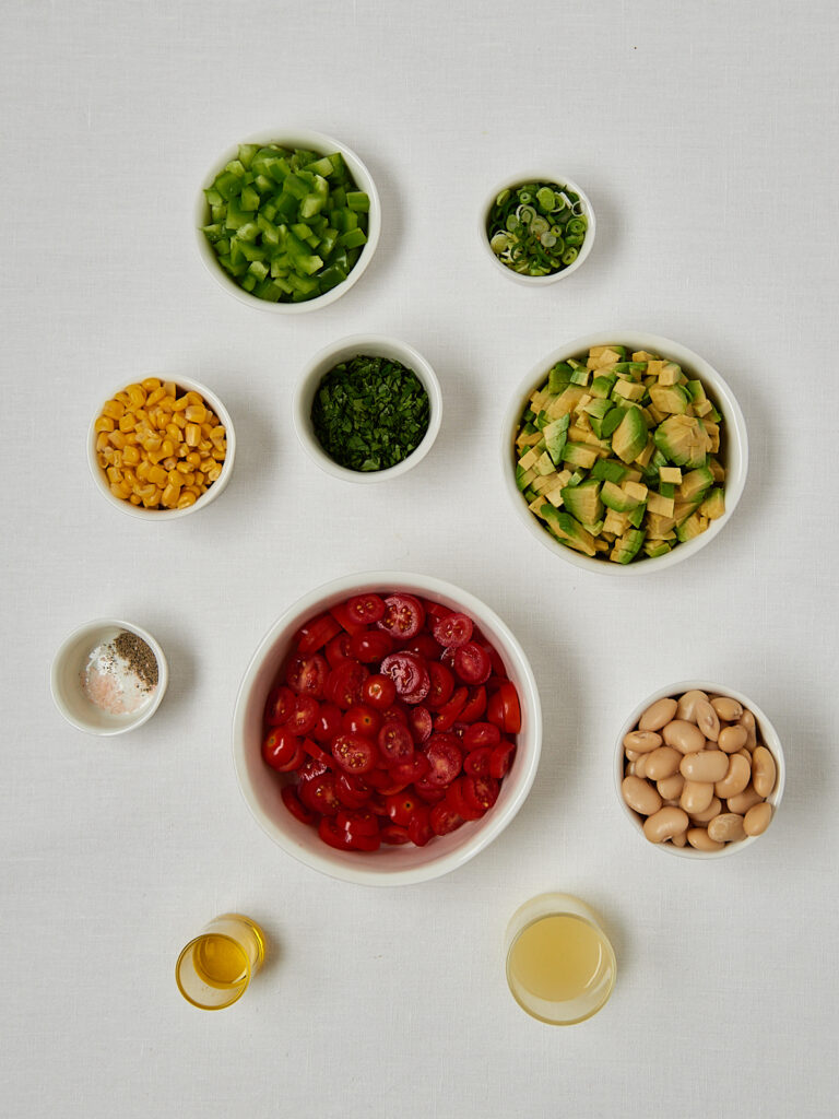 Zutaten Butter Bean Corn Salad &ndash; Bohnen, Mais, Kr&auml;uter in Sch&auml;lchen Overhead Shot