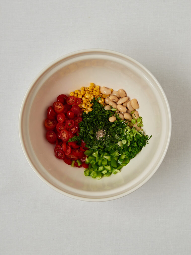 Zutaten-Flatlay Butter Bean Corn Salad &ndash; Edamame, Petersilie, Kirschtomaten und wei&szlig;e Bohnen