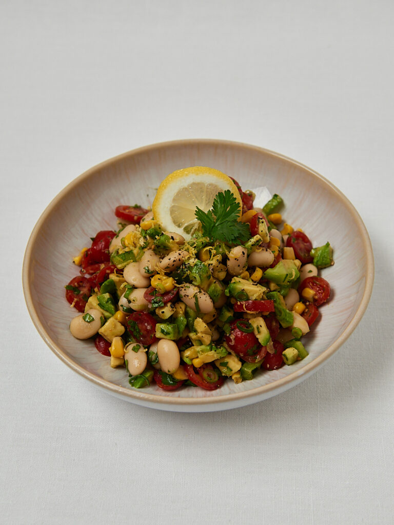 Butter Bean Corn Salad mit Kirschtomaten, Edamame und Zitrone in beiger Sch&uuml;ssel &ndash; gesunder Sommersalat