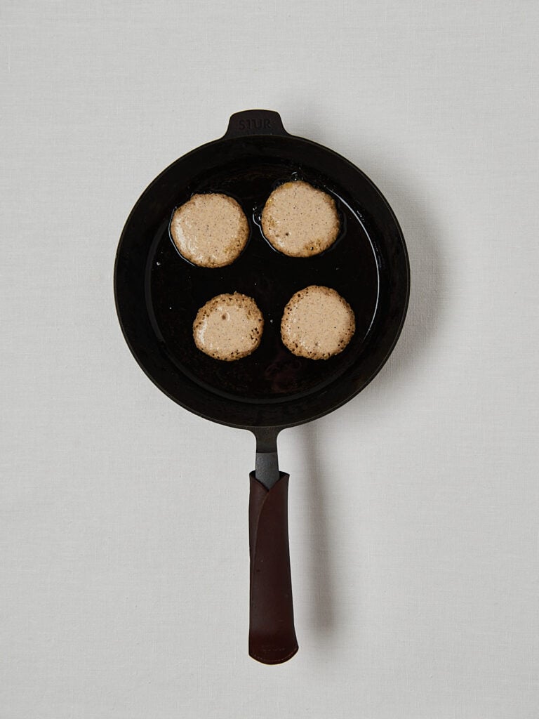 Gesunde Haferflocken Pancakes in schwarzer Pfanne – Zubereitungsschritt Draufsicht