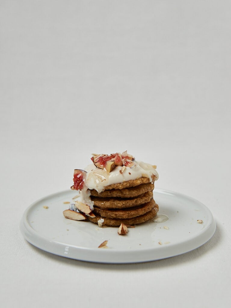 Gesunde Oatmeal Pancakes mit Joghurt und Früchten auf Teller – frontale Aufnahme