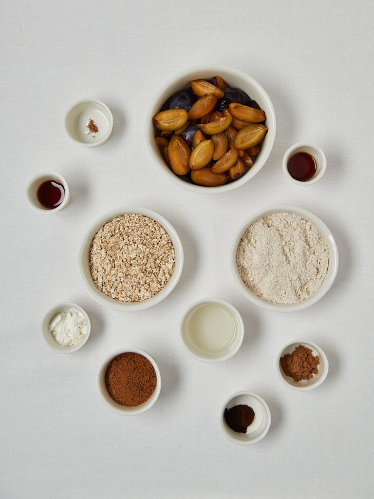Zutaten-Flatlay Pflaumen Crumble &ndash; Mandeln, Hafermehl, Zimt und Ahornsirup