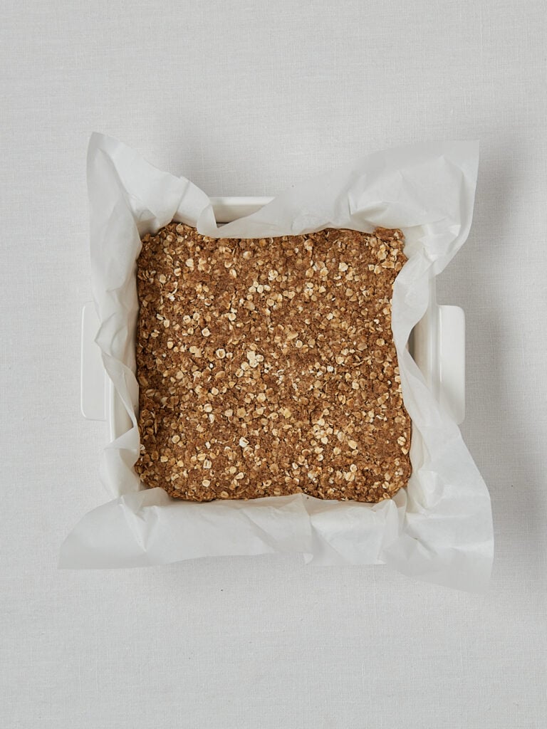 Haferflocken Crumble Boden in Backpapierform &ndash; Overhead Zubereitungsschritt