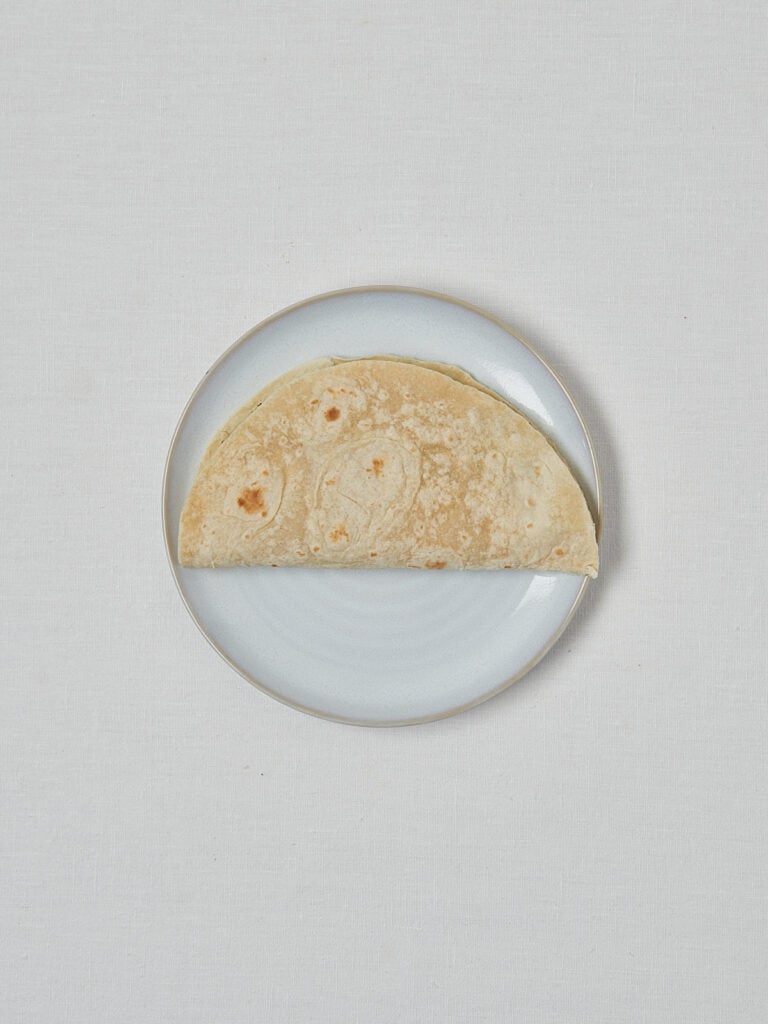 Leerer Vollkorn Wrap auf weißem Teller – Vorbereitung Bohnen Pesto Wrap
