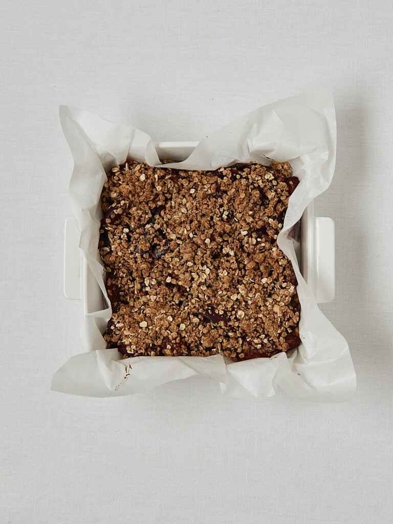 Pflaumen Crumble in Backform mit Streuselbelag &ndash; Overhead Shot vor dem Schneiden