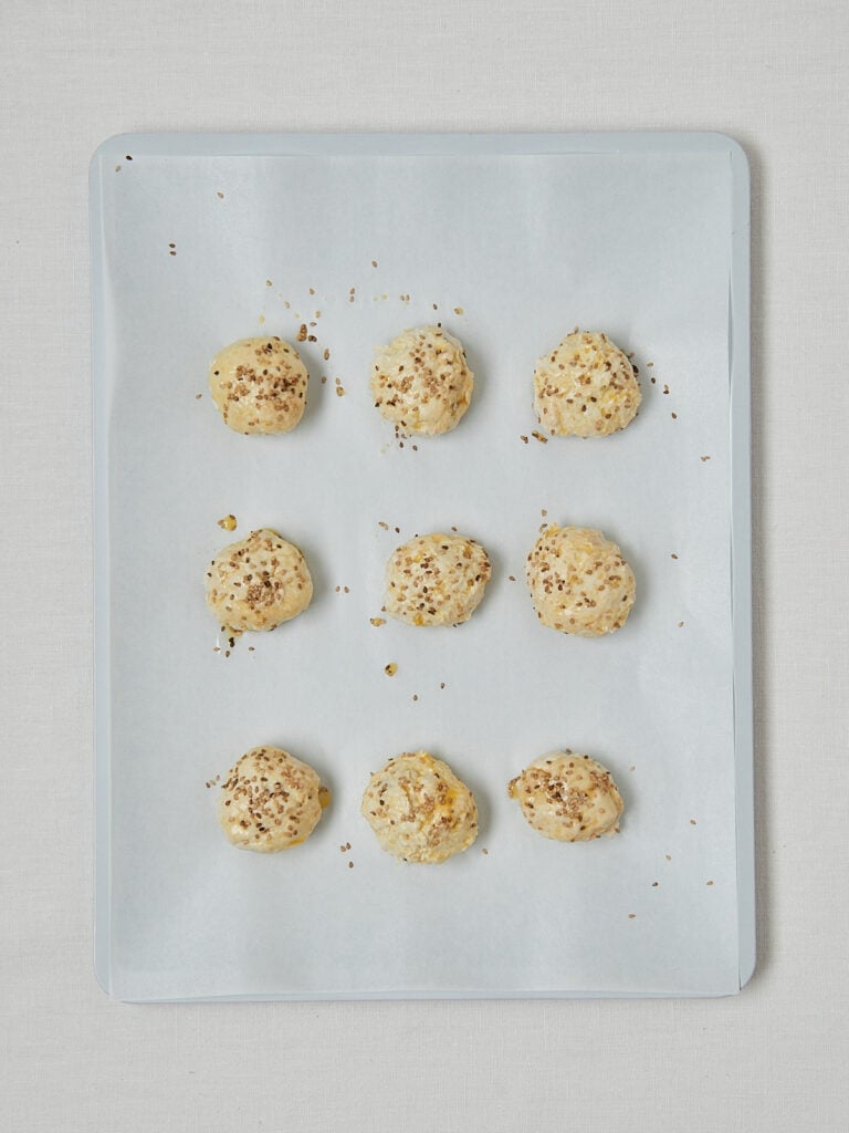 Bagel Bites Teigkugeln mit Sesam auf Backblech – Zubereitungsschritt vor dem Backen