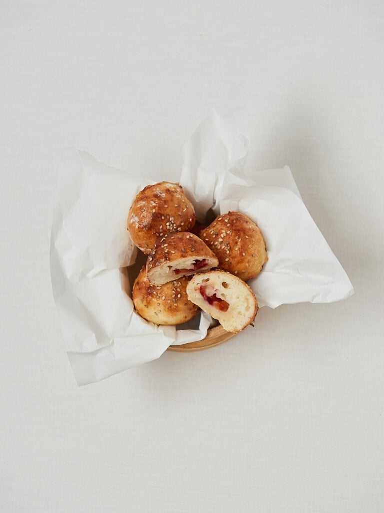 Knusprige Pflaumen Bites mit sichtbarer Füllung in Backpapier – frontale Aufnahme