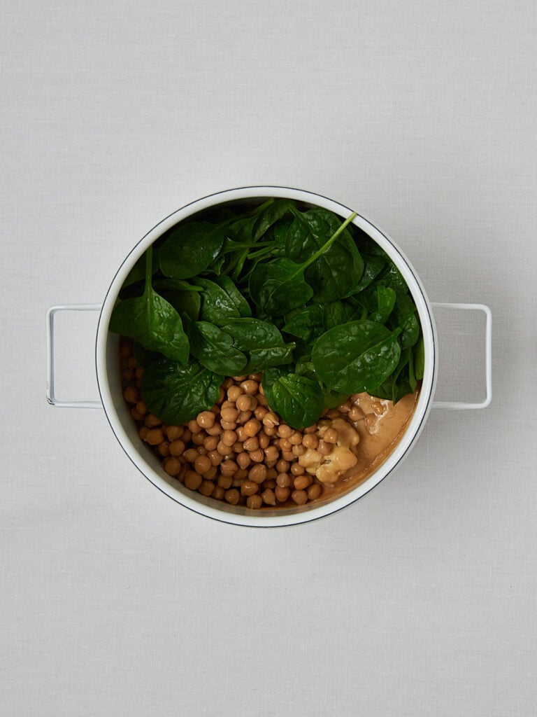 Spinat und Blumenkohl in weißer Schüssel – Zubereitungsschritt Overhead